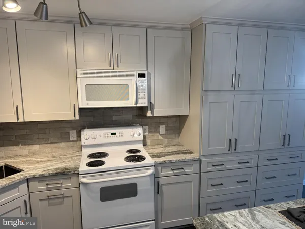 a kitchen with appliances a stove and cabinets