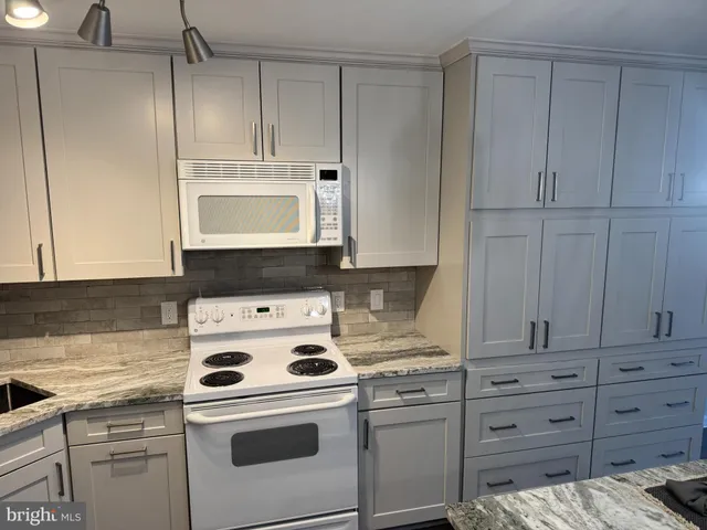 a kitchen with appliances a stove and cabinets