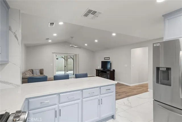 a kitchen with stainless steel appliances kitchen island granite countertop a refrigerator and a sink