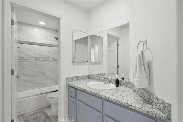a bathroom with a granite countertop sink mirror and shower