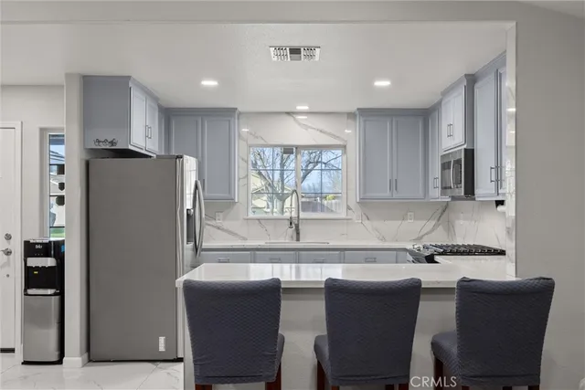 a kitchen with a table chairs refrigerator and microwave