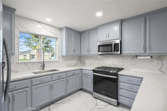 a kitchen with sink a microwave and cabinets