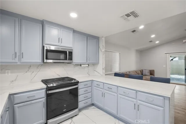 a kitchen with granite countertop white cabinets white stainless steel appliances and a sink