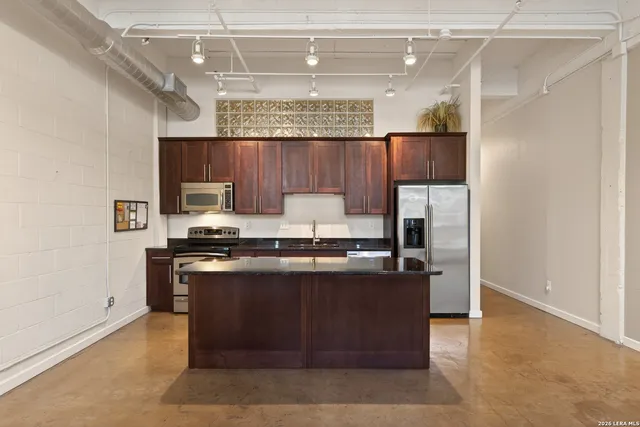 a kitchen with stainless steel appliances granite countertop a stove a sink and a refrigerator