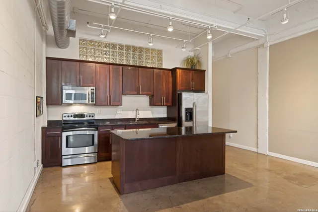 a kitchen with stainless steel appliances granite countertop a sink stove and refrigerator