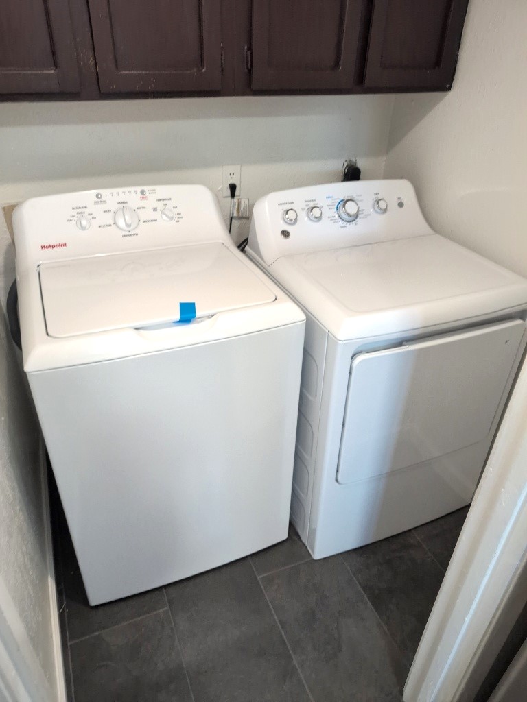 3413 Lynridge Drive, Unit B Austin, TX 78723 - Photo 12 of 23 Laundry room with dark tile patterned floors, cabinet space, and washing machine and clothes dryer