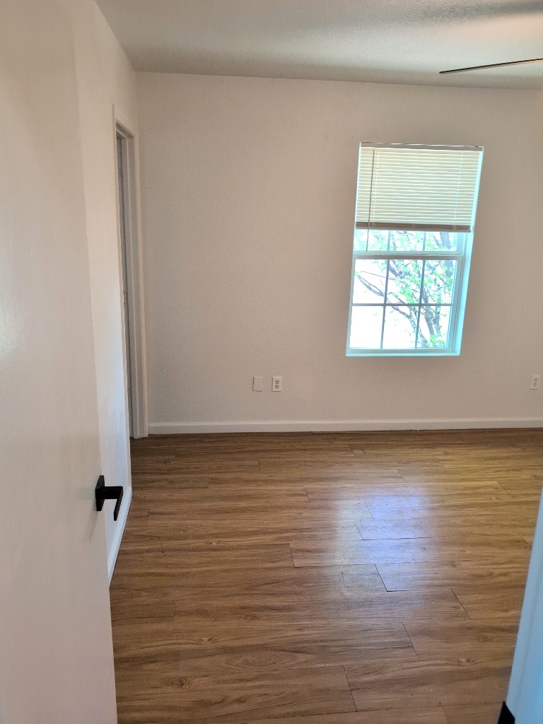 3413 Lynridge Drive, Unit B Austin, TX 78723 - Photo 14 of 23 Unfurnished room featuring wood finished floors and baseboards