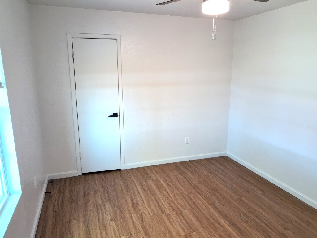 3413 Lynridge Drive, Unit B Austin, TX 78723 - Photo 15 of 23 an empty room with wooden floor and windows