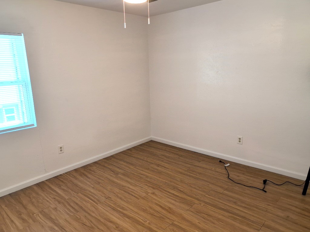 3413 Lynridge Drive, Unit B Austin, TX 78723 - Photo 18 of 23 a view of an empty room with wooden floor and a window