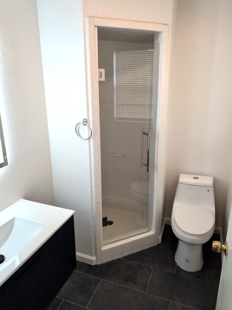 3413 Lynridge Drive, Unit B Austin, TX 78723 - Photo 21 of 23 Full bathroom with vanity, toilet, a shower stall, and tile patterned flooring