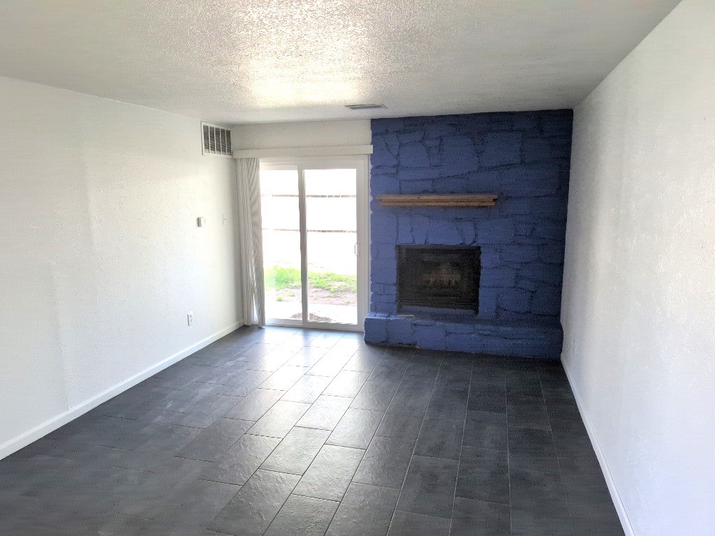 3413 Lynridge Drive, Unit B Austin, TX 78723 - Photo 4 of 23 a view of an empty room with a fireplace and a window
