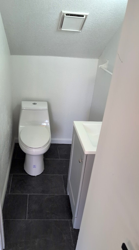3413 Lynridge Drive, Unit B Austin, TX 78723 - Photo 7 of 23 Bathroom featuring baseboards, toilet, vanity, and a textured ceiling