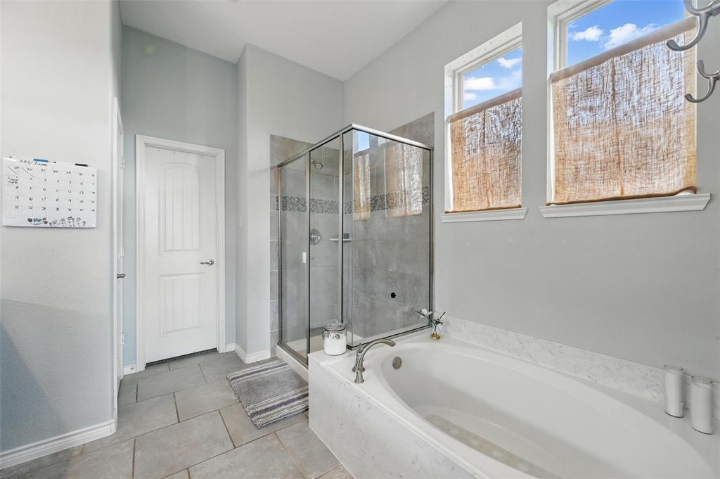 408 Mission Drive Forney, TX 75126 - Photo 17 of 40 Bathroom with a garden tub, a shower stall, tile patterned floors, and baseboards