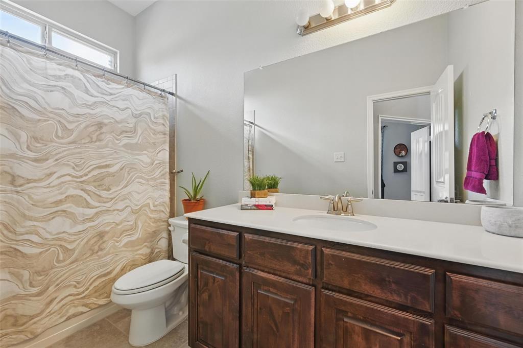 408 Mission Drive Forney, TX 75126 - Photo 22 of 40 Bathroom featuring toilet, vanity, curtained shower, and tile patterned flooring