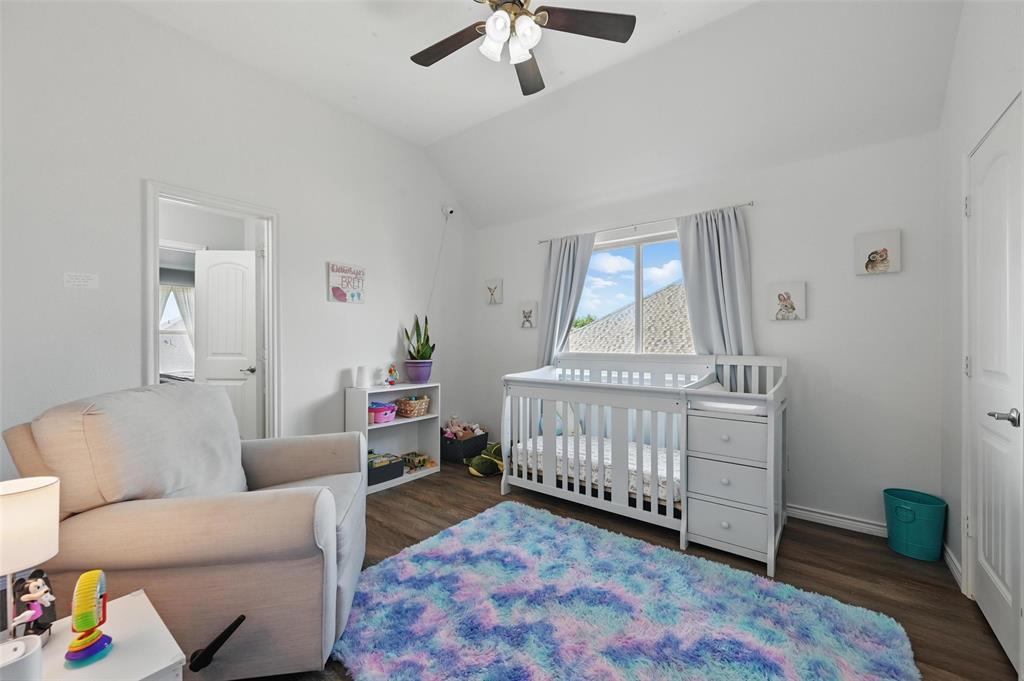 408 Mission Drive Forney, TX 75126 - Photo 28 of 40 Bedroom with wood finished floors, lofted ceiling, baseboards, a nursery area, and ceiling fan
