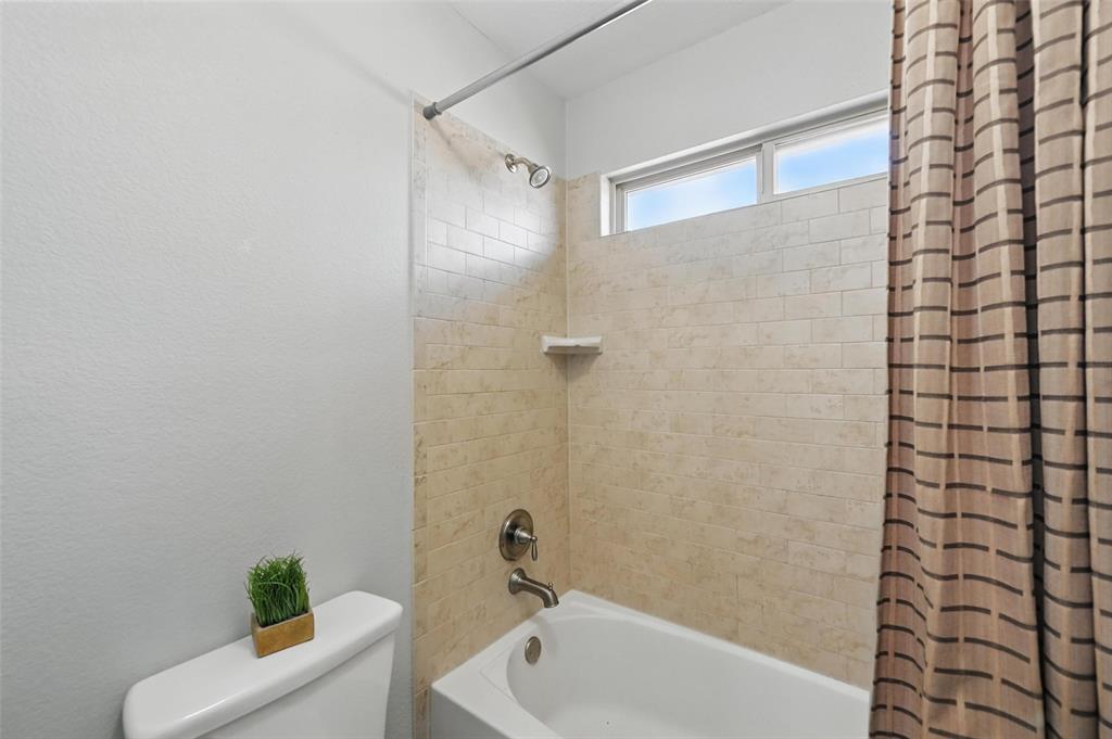 408 Mission Drive Forney, TX 75126 - Photo 31 of 40 Bathroom featuring shower / bath combo with shower curtain and toilet