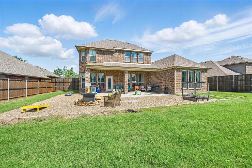 408 Mission Drive Forney, TX 75126 - Photo 32 of 40 Rear view of house with brick siding, a fire pit, and a patio