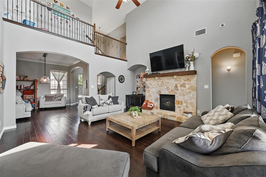 408 Mission Drive Forney, TX 75126 - Photo 6 of 40 Living area with ceiling fan, a high ceiling, hardwood / wood-style floors, baseboards, and a fireplace
