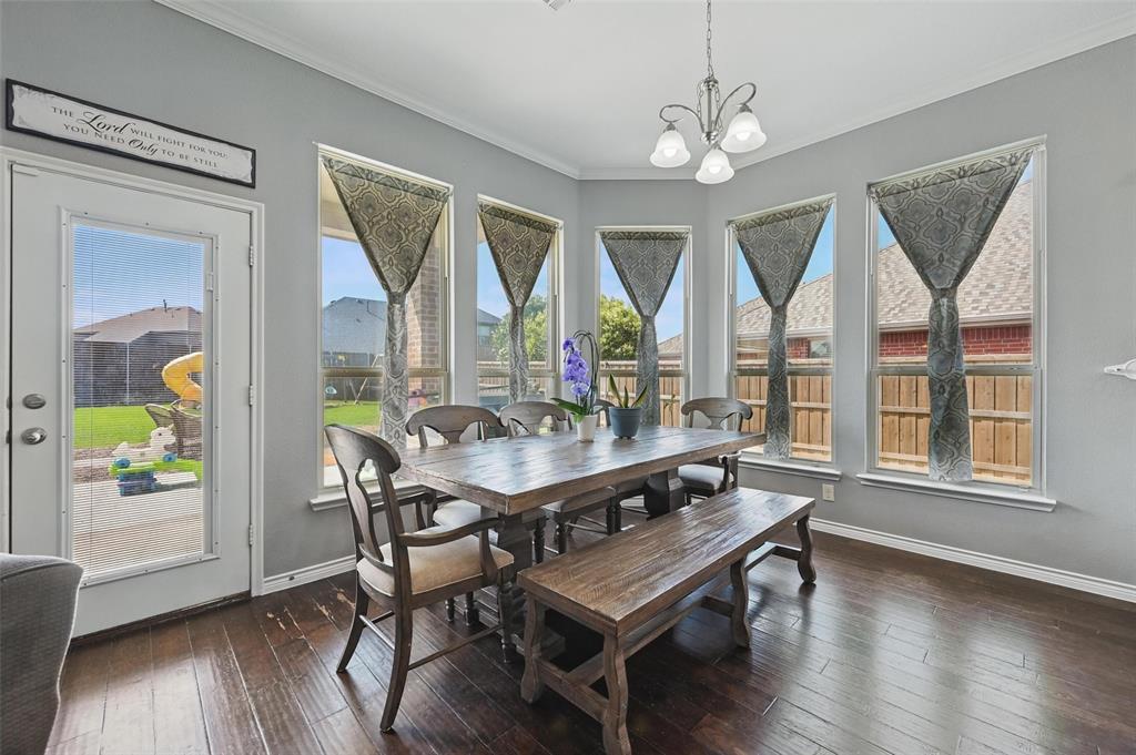 408 Mission Drive Forney, TX 75126 - Photo 7 of 40 Dining area with ornamental molding, hardwood / wood-style flooring, a chandelier, and baseboards