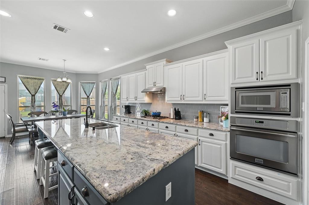 408 Mission Drive Forney, TX 75126 - Photo 10 of 40 Kitchen featuring stainless steel appliances, a sink, white cabinets, an island with sink, and recessed lighting