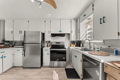 a kitchen with white cabinets and white appliances