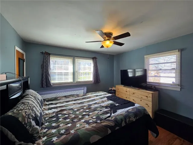 a bedroom with a bed and a tv on dresser