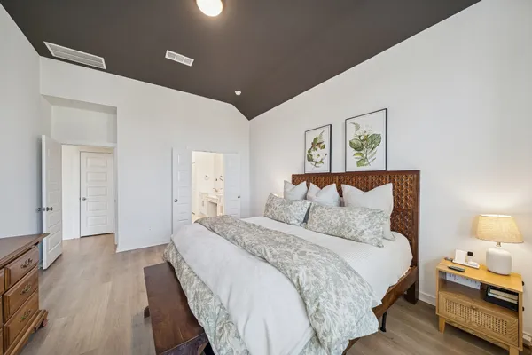 a bedroom with bed and wooden floor