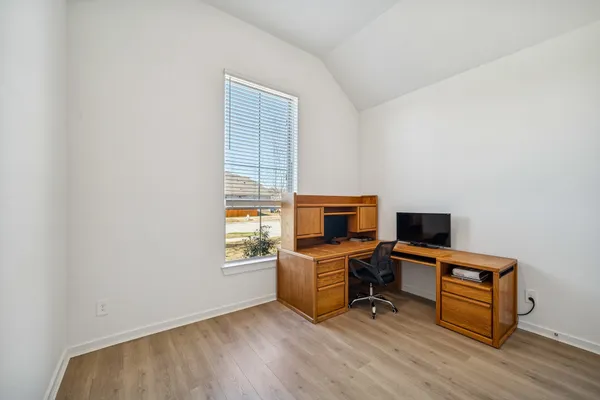 a view of a workspace with furniture and a window