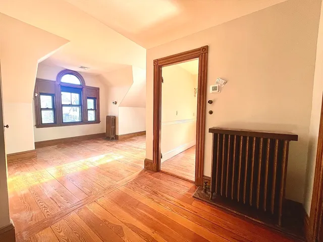 a view of a room with wooden floor and a bathroom
