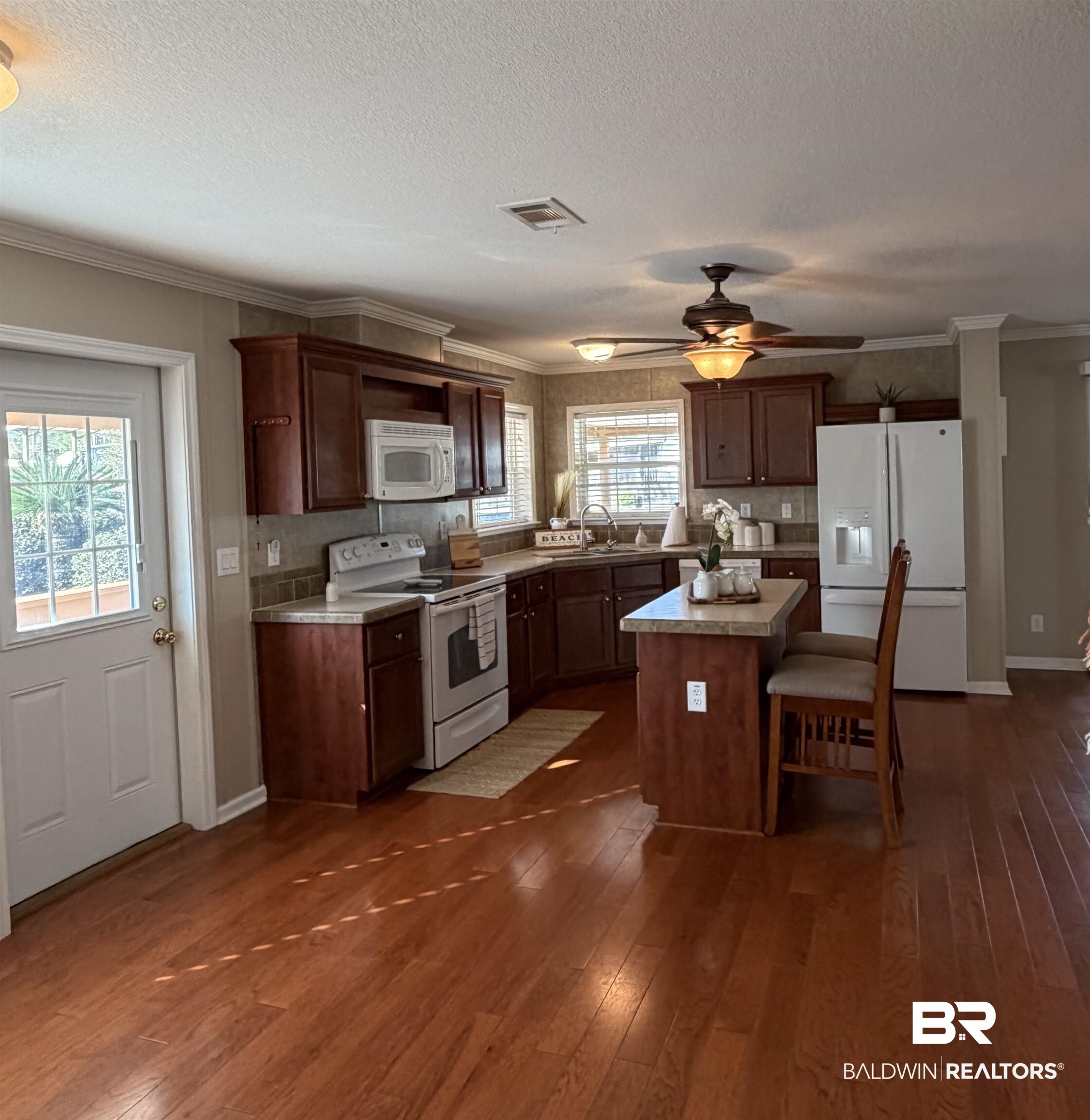 675 Escambia Loop Lillian, AL 36549 - Photo 12 of 44 Kitchen with white appliances, light countertops, dark brown cabinetry, a center island, and ceiling fan