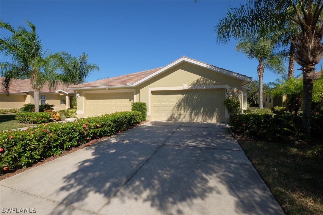4664 Fairloop Run Lehigh Acres, FL 33973 - Photo 1 of 24 a front view of a house with a garden