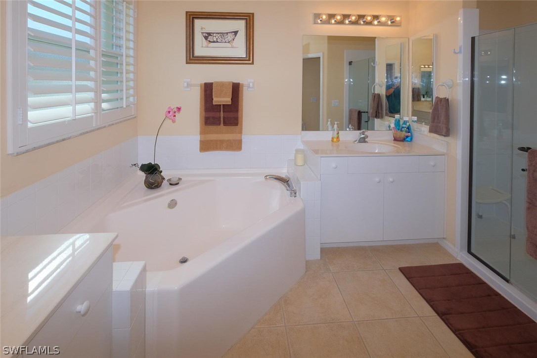 4664 Fairloop Run Lehigh Acres, FL 33973 - Photo 14 of 24 a bathroom with a bathtub and a sink