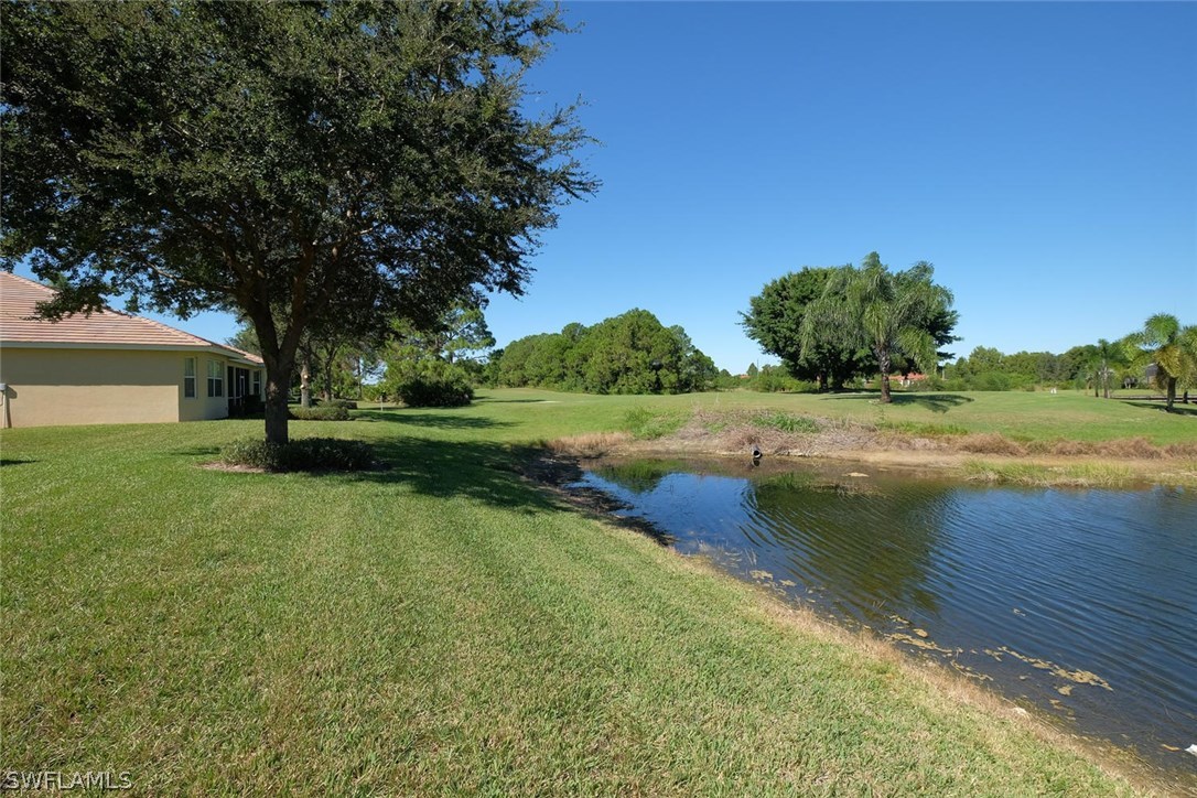 4664 Fairloop Run Lehigh Acres, FL 33973 - Photo 23 of 24 a view of a lake with a yard