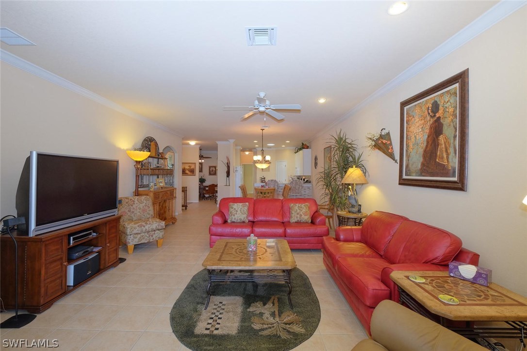4664 Fairloop Run Lehigh Acres, FL 33973 - Photo 4 of 24 a living room with furniture and a flat screen tv