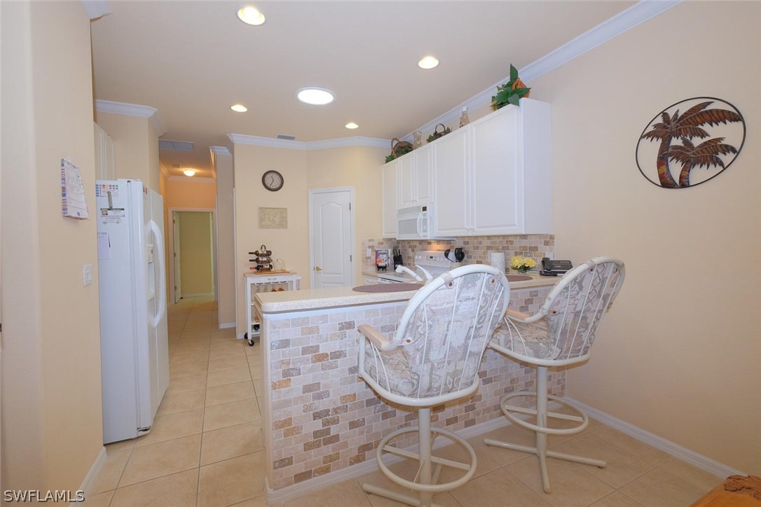 4664 Fairloop Run Lehigh Acres, FL 33973 - Photo 7 of 24 a view of dining room and kitchen with furniture wooden floor and a chandelier