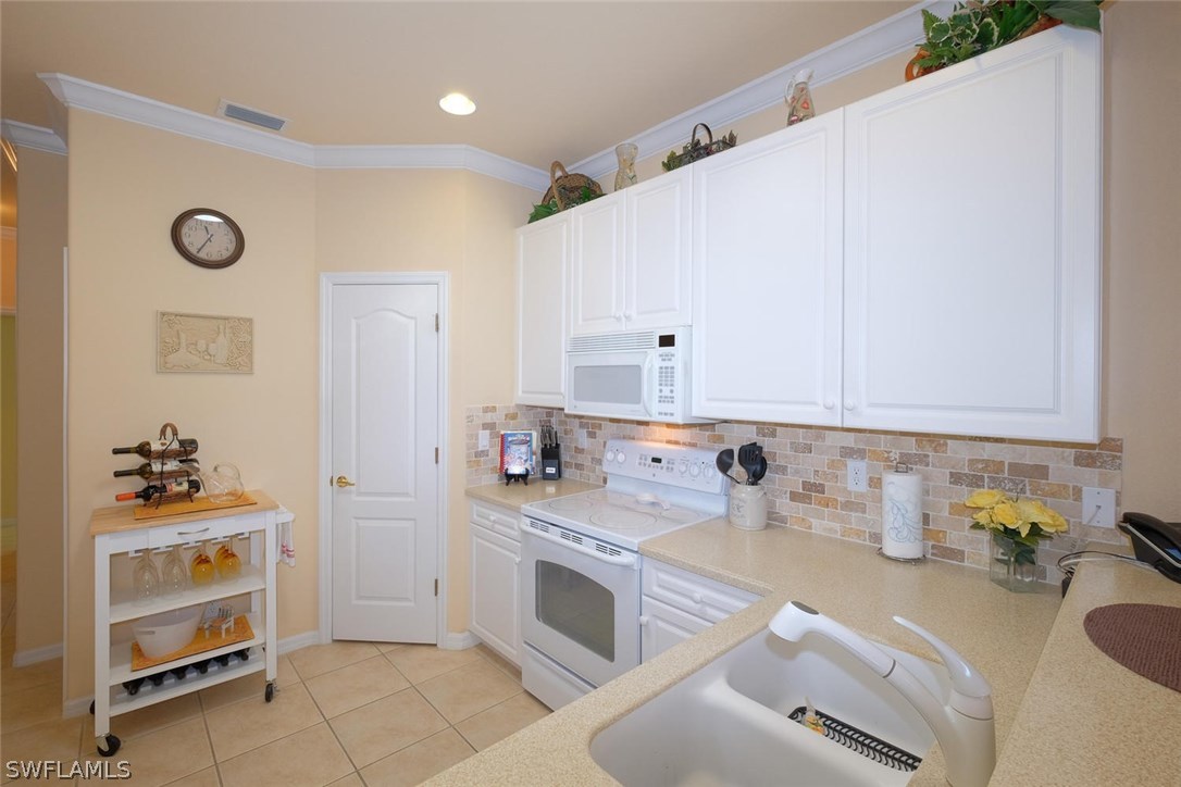 4664 Fairloop Run Lehigh Acres, FL 33973 - Photo 8 of 24 a kitchen with a sink stove and cabinets