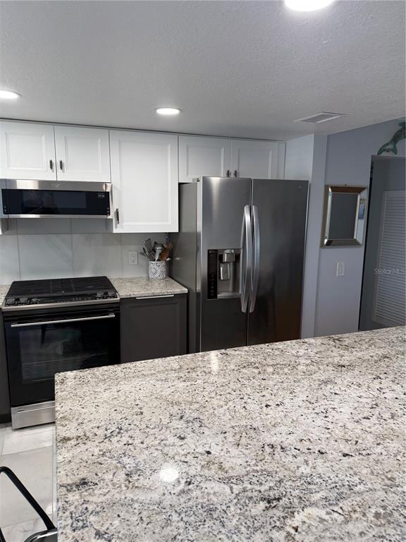 1868 Shore Drive South, Unit 608 South Pasadena, FL 33707 - Photo 6 of 36 a kitchen with stainless steel appliances kitchen island granite countertop a refrigerator and a stove top oven