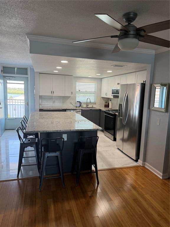 1868 Shore Drive South, Unit 608 South Pasadena, FL 33707 - Photo 7 of 36 a kitchen with stainless steel appliances granite countertop a dining table chairs refrigerator sink and cabinets