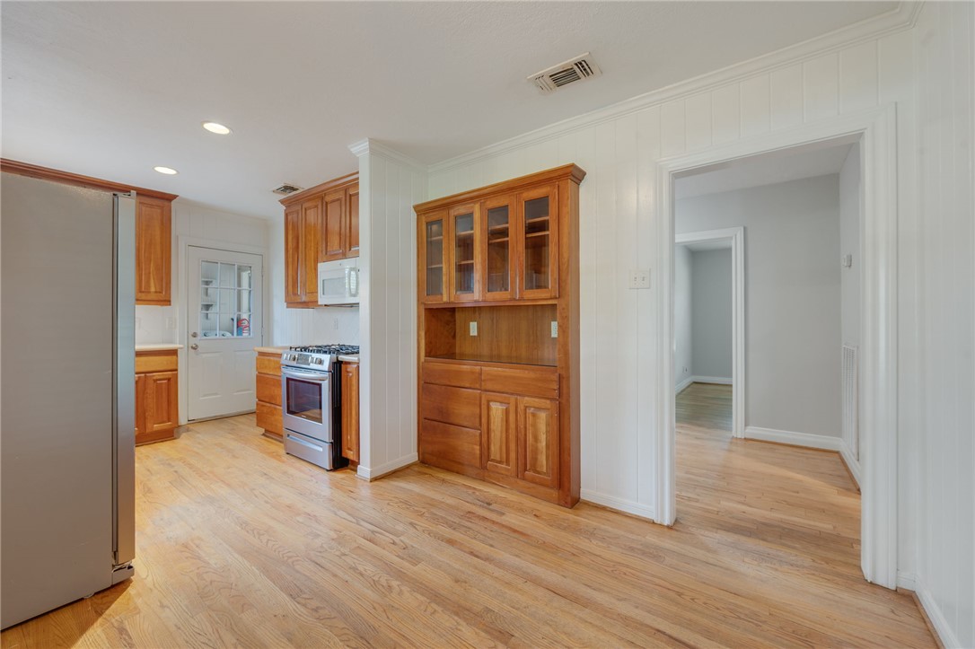 715 Inwood Drive Bryan, TX 77802 - Photo 3 of 34 a view of a kitchen with refrigerator and wooden floor