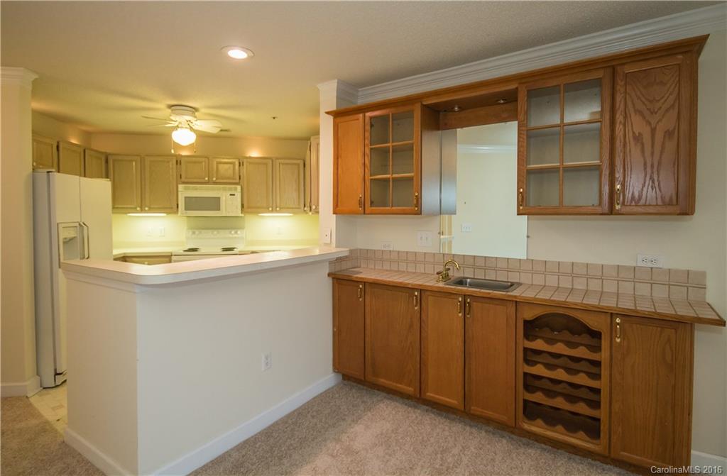1129 Torrence Circle, Unit 1129 Davidson, NC 28036 - Photo 2 of 20 a kitchen with stainless steel appliances granite countertop a sink and cabinets with wooden floor
