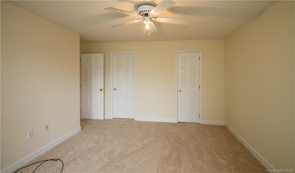 1129 Torrence Circle, Unit 1129 Davidson, NC 28036 - Photo 11 of 20 an empty room with closet and a chandelier fan