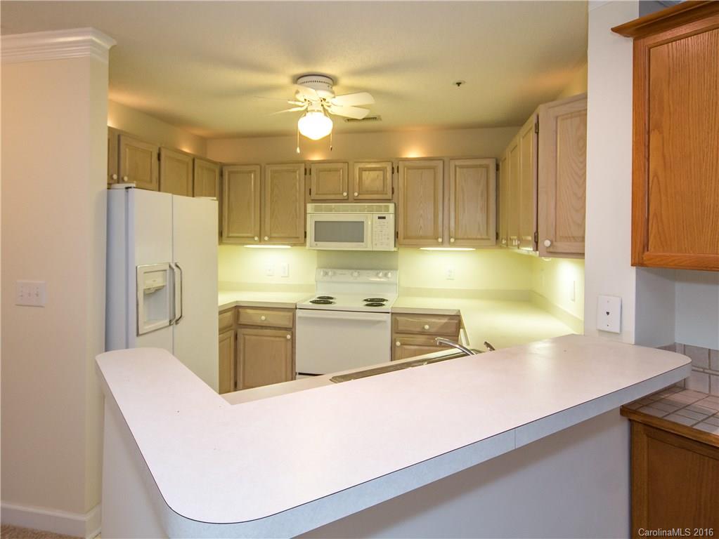 1129 Torrence Circle, Unit 1129 Davidson, NC 28036 - Photo 3 of 20 a kitchen with stainless steel appliances granite countertop a sink a stove and a refrigerator