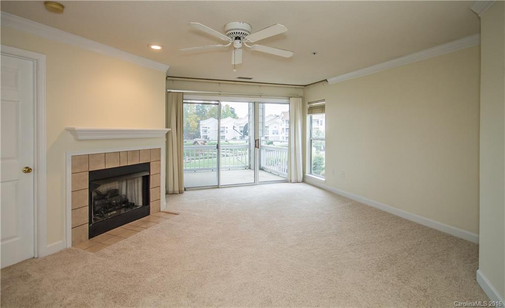 1129 Torrence Circle, Unit 1129 Davidson, NC 28036 - Photo 4 of 20 a view of an empty room with a fireplace and a window