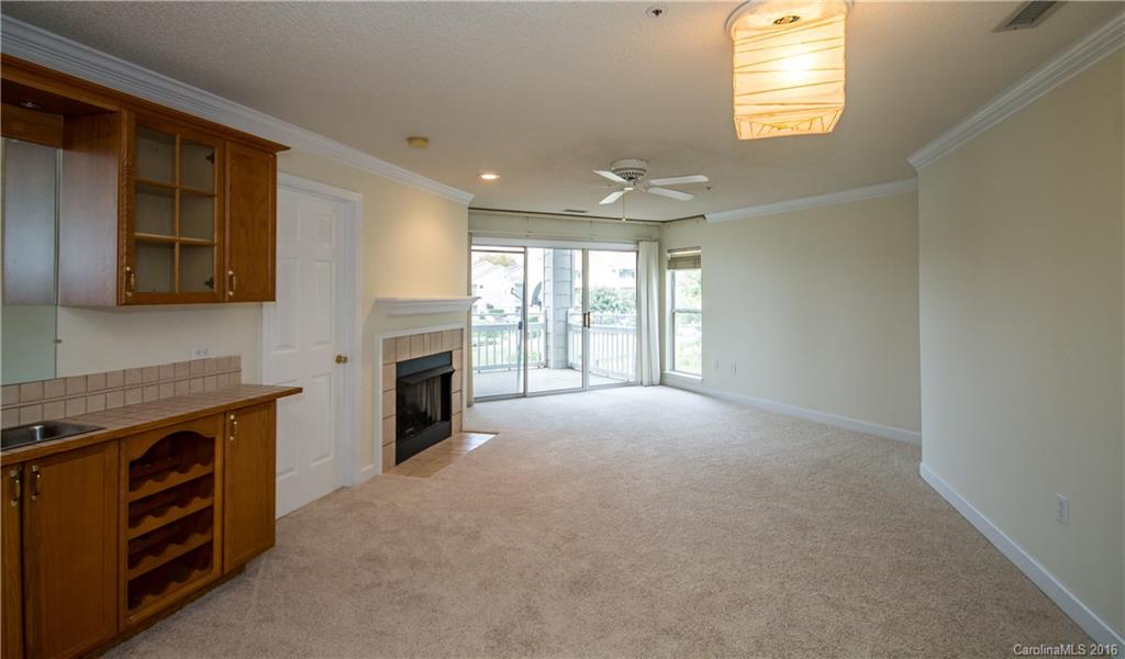 1129 Torrence Circle, Unit 1129 Davidson, NC 28036 - Photo 5 of 20 a view of an empty room with a fireplace and a window