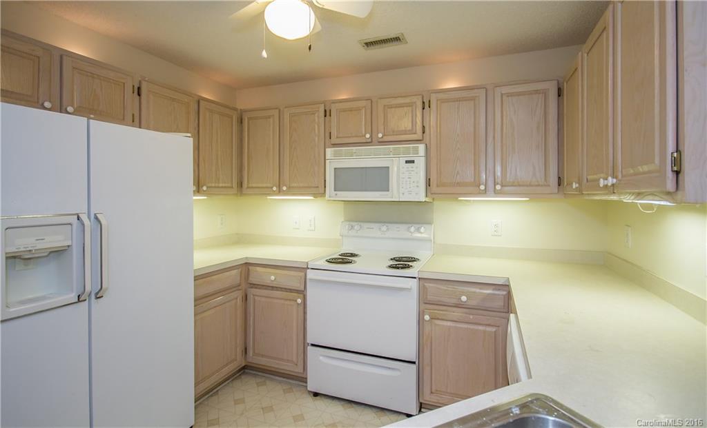 1129 Torrence Circle, Unit 1129 Davidson, NC 28036 - Photo 6 of 20 a kitchen with a refrigerator sink and cabinets