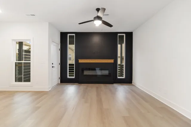 a view of an empty room with a fireplace and a window