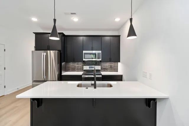 a kitchen with a sink a counter space and stainless steel appliances