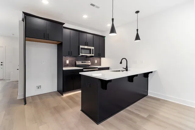 a kitchen with kitchen island a sink stainless steel appliances and cabinets