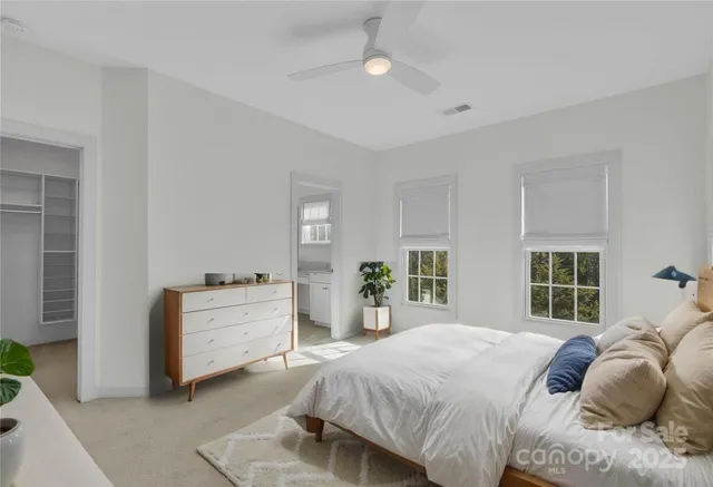a bedroom with a large bed and windows