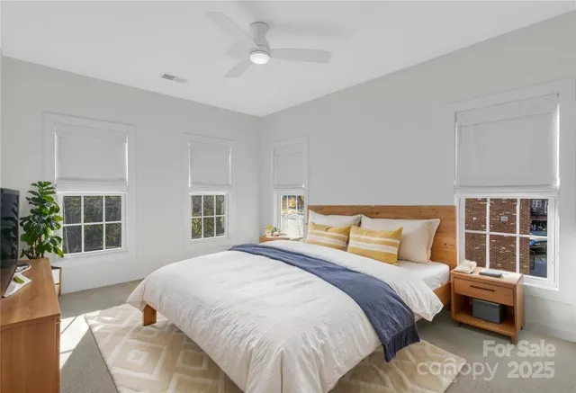 a bedroom with a large bed and windows